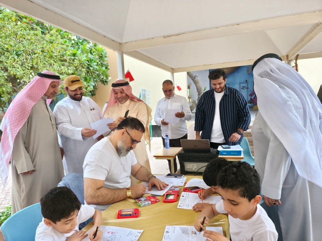 نشاط ميداني تحت مظلة: كبار وطلاب يشاركون في الرسم والتلوين مع أعلام بحرينية في الخلفية