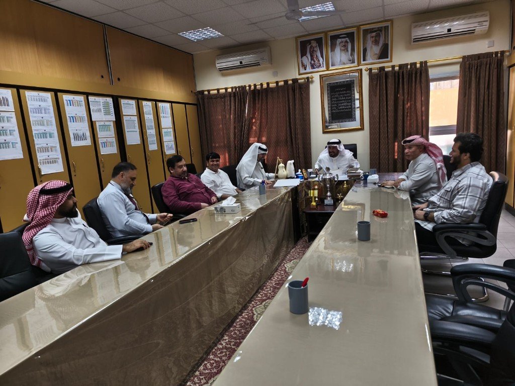 اجتماع موسّع لفريق القسم حول طاولة اجتماعات مع توثيق حضوري
