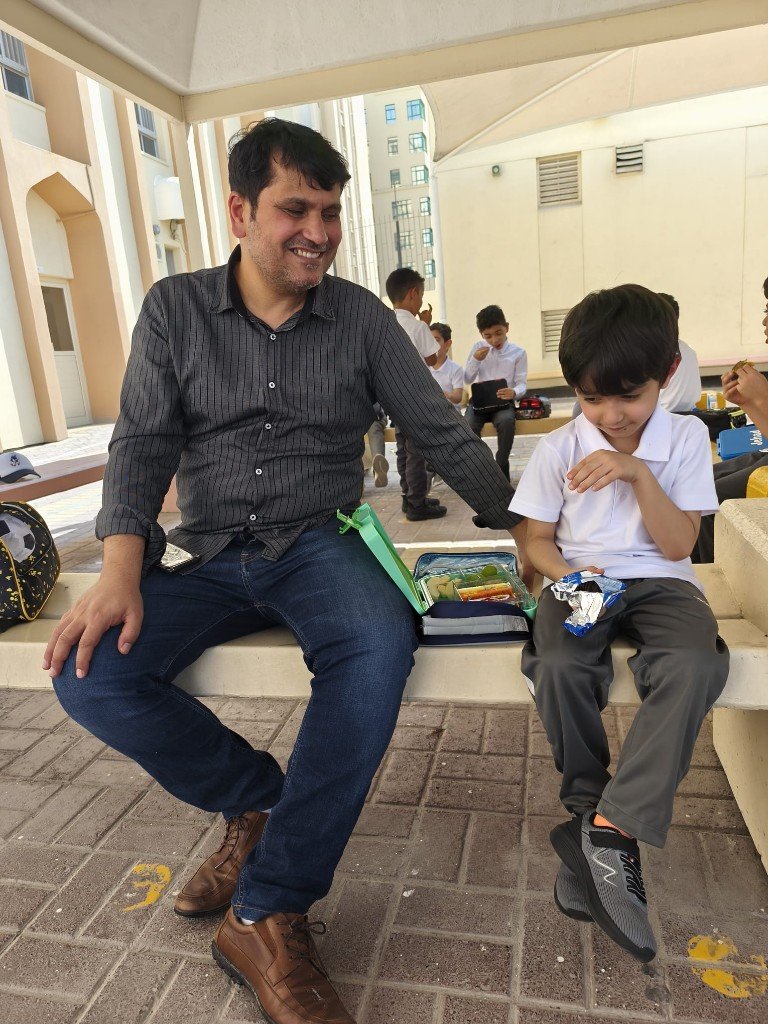 أ. يوسف حسن مع طالب أثناء استراحة في الفناء — تفاعل وتوجيه