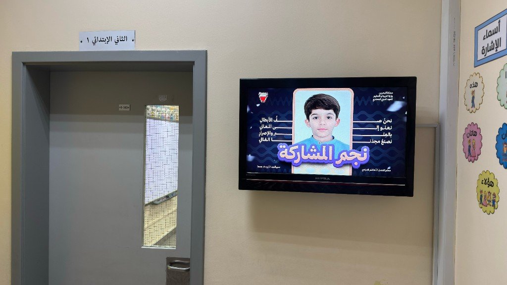 شاشة تلفاز في رواق صف الثاني الابتدائي ١ تعرض نجوم المشاركة والإعلانات التحفيزية